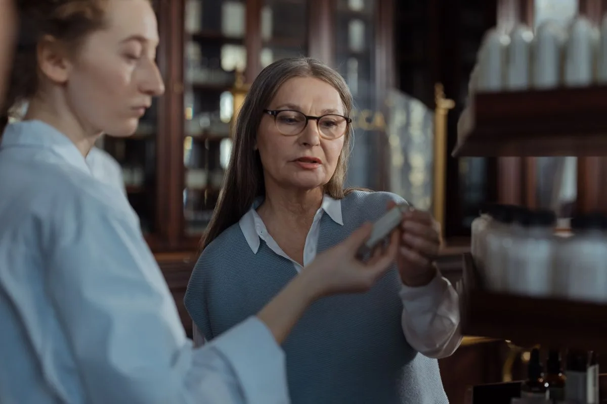 Patient discussing medication options with a pharmacist at the counter